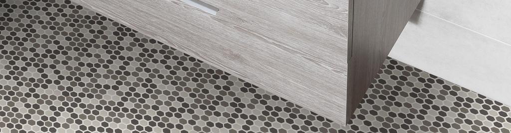 Suelo de baño con mosaico hexagonal gris y mueble de madera.